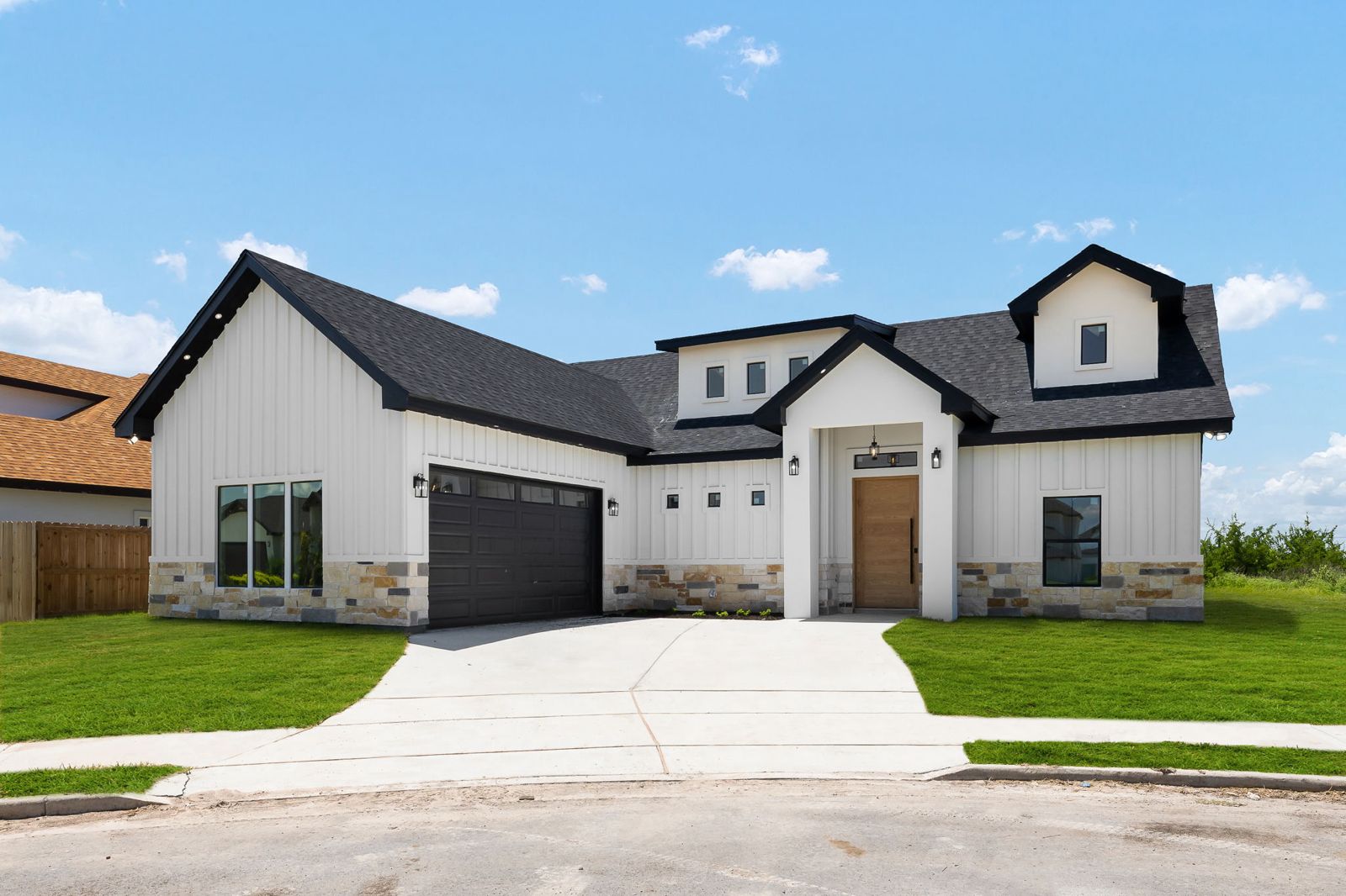 Modern farmhouse front elevation in daylight with a cedar front door — The Modern Farmhouse, a Kratos Construction custom home