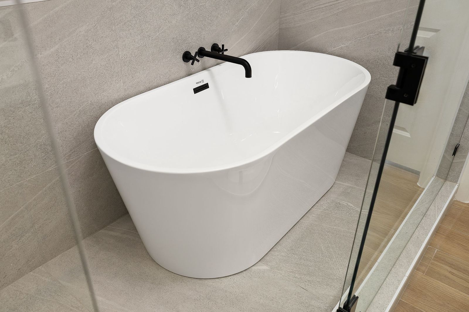 Freestanding tub with a wall-mounted black faucet — The Modern Farmhouse, a Kratos Construction custom home
