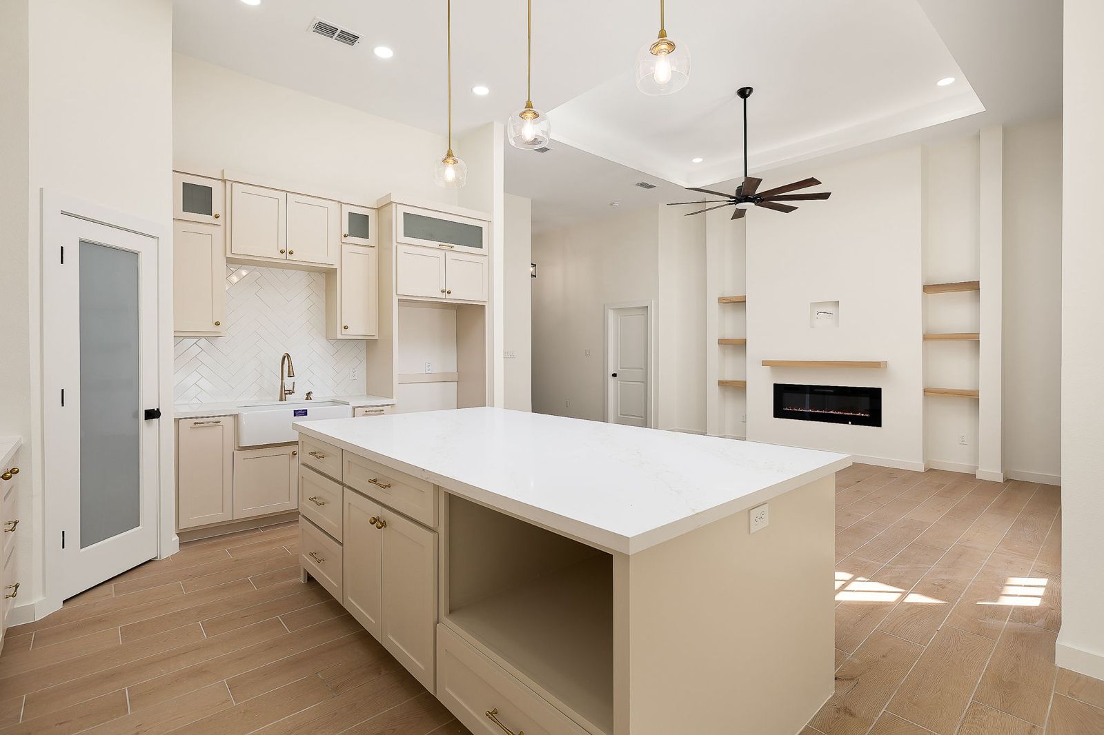 Kitchen island open to the living room fireplace — The Hill Country, a Kratos Construction custom home