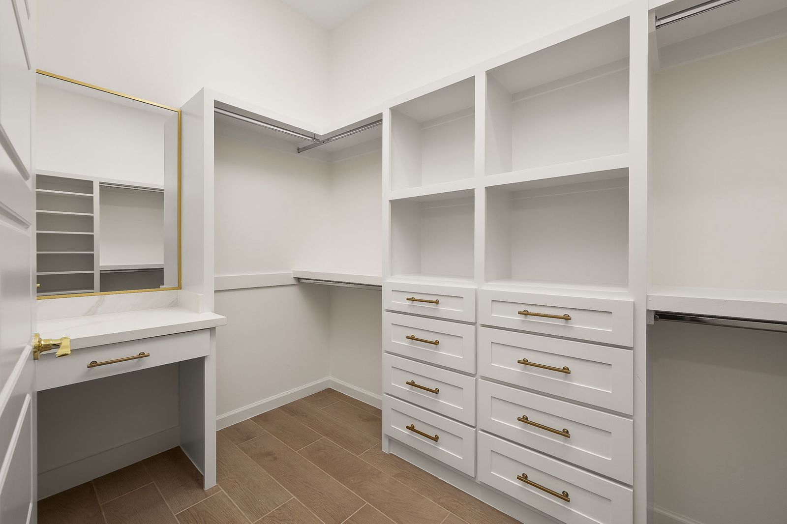 Walk-in closet with built-in drawers and a vanity — The Stone Column, a Kratos Construction custom home