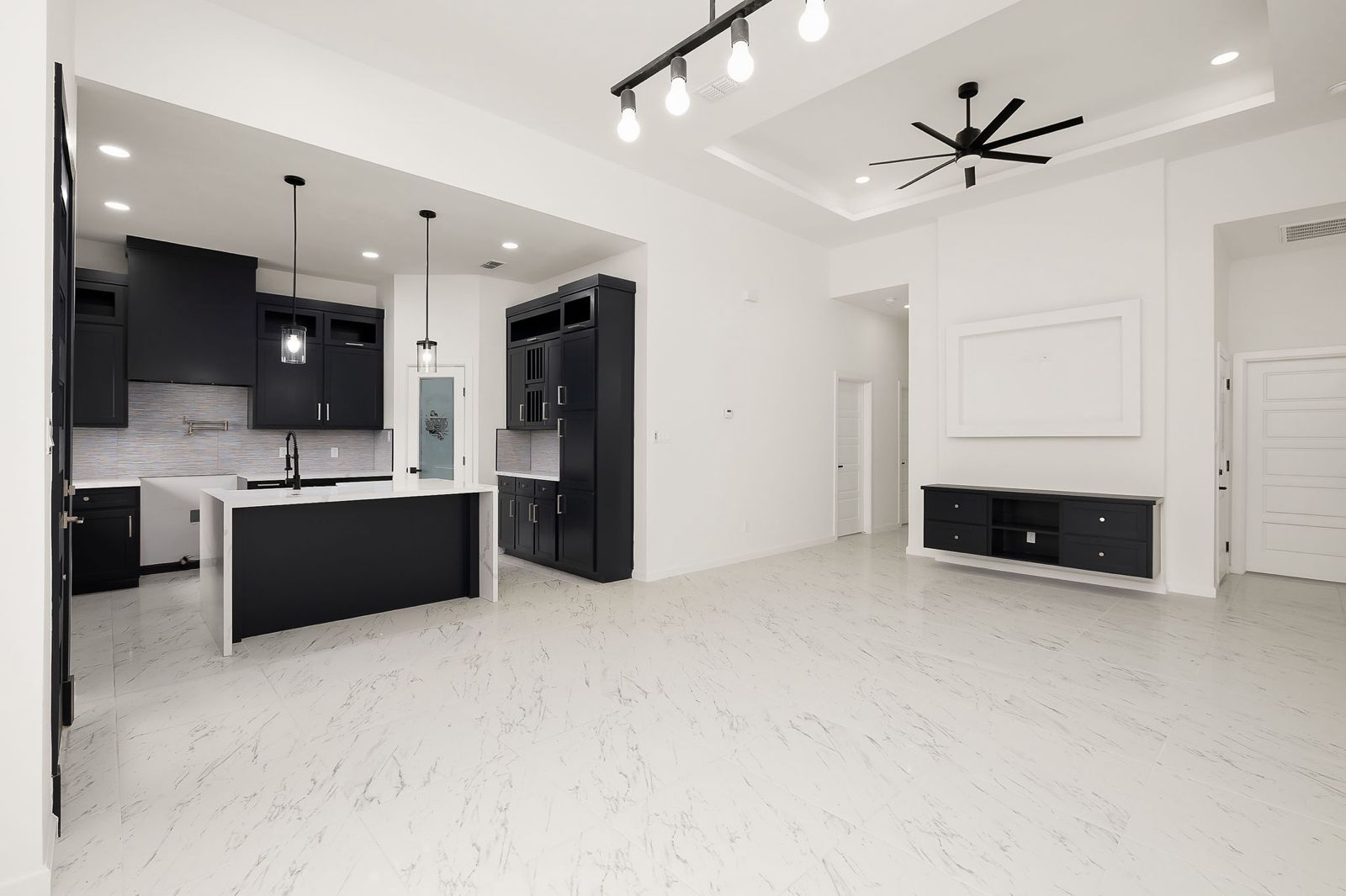 Open kitchen and living room with a tray ceiling — The Stucco & Stone, a Kratos Construction custom home