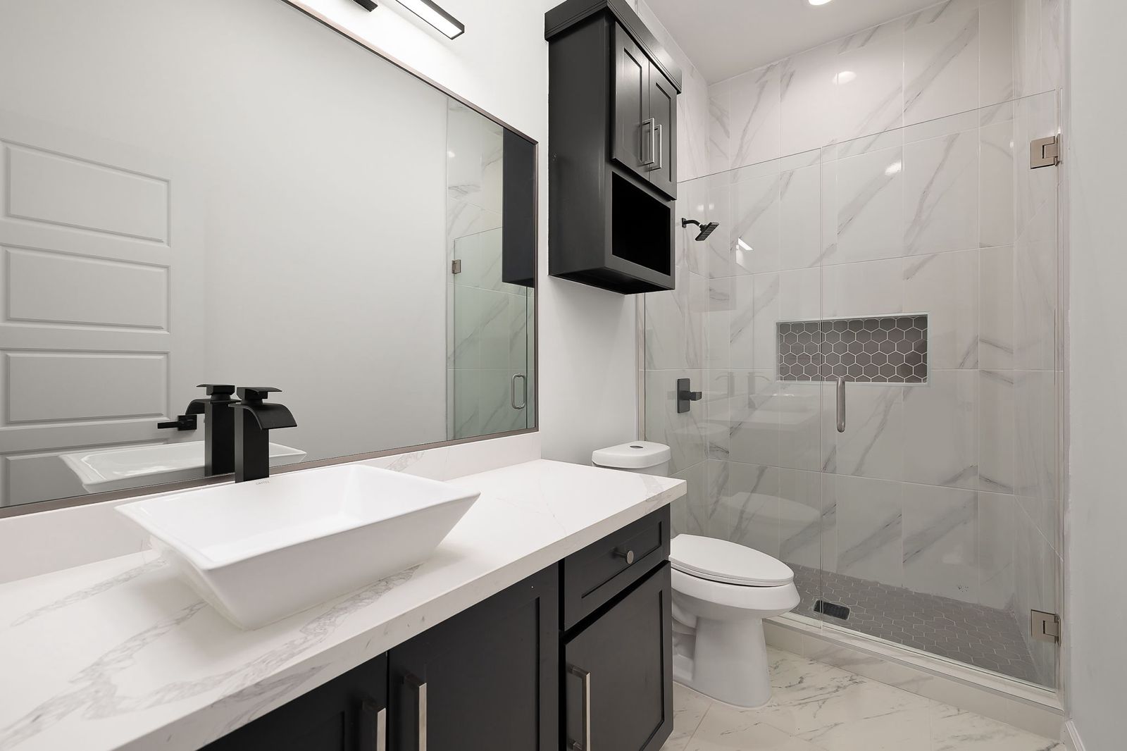 Bathroom with a vessel sink and glass walk-in shower — The Stucco & Stone, a Kratos Construction custom home