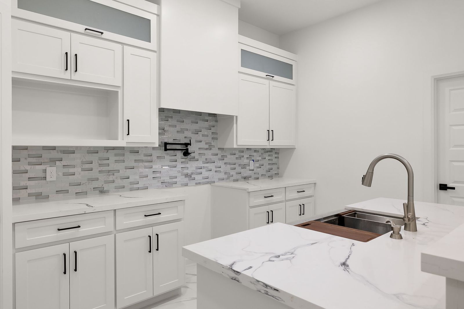 White shaker kitchen with a mosaic backsplash and quartz countertops — The Timber Gable, a Kratos Construction custom home