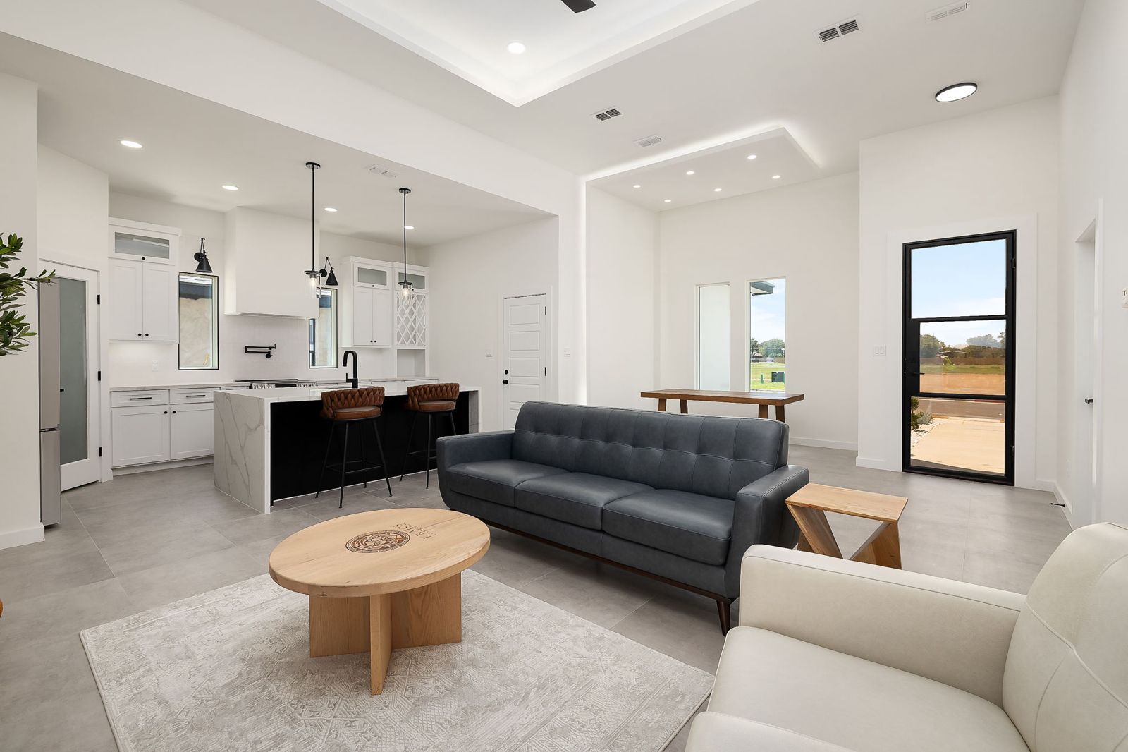 Open living, dining and kitchen with tray ceilings — The White Brick, a Kratos Construction custom home
