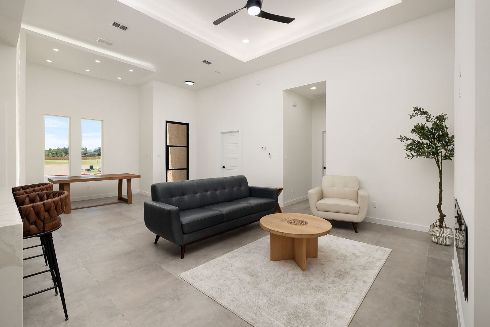 Living room and dining area with a bar-height island — The White Brick, a Kratos Construction custom home